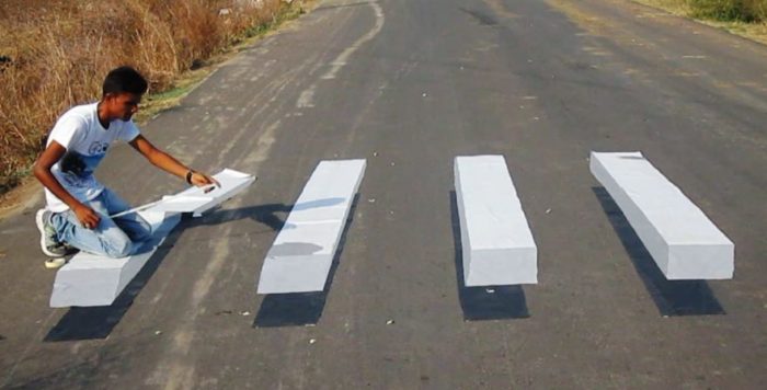PIC FROM CATERS NEWS - (PICTURED: The Beetles 3D zebra crossing) - A mechanical engineer is fascinating everyone with his jaw-dropping 3D road marking illusions that blur the lines between reality and art. Shivrama Krishna, 26, has no formal training in the highly specialised form of art but the passionate cartoonist creates incredible 3D illusion drawings across roads and rooftops. Krishna uses a range of paint brushes and paint stainers to craft his optical illusions, which include a larger than life size swimming pool, staircase and Eiffel Tower on paper sheets. The son a farmer from Karimnagar in Telangana in southern India, Krishna always had a knack for drawings and spends around three to four hours complete each one. SEE CATERS COPY.